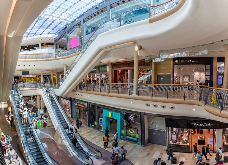 Centro comercial con escaleras mecánicas y visitantes