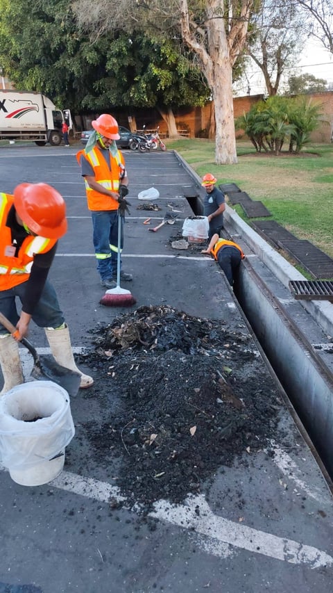 Trabajadores realizando mantenimiento de drenaje en vía pública